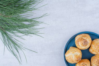 Çam ağacı dallı mavi tabakta fırında tatlı rulo. Yüksek kalite fotoğraf