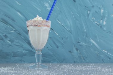 Mavi arka planda bir bardak aromalı milkshake. Yüksek kalite fotoğraf