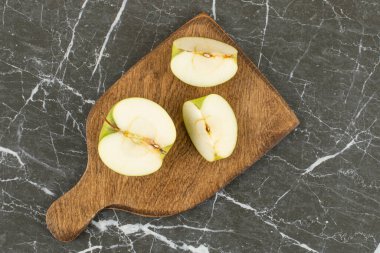 Tahta kesme tahtasında dilimlenmiş ve yarısı kesilmiş yeşil elma. Yüksek kalite fotoğraf