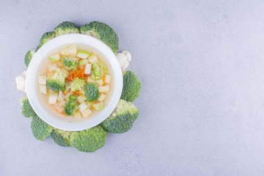 Brokoli çemberi mermer arka planda sebze salatasının bir kısmı etrafında. Yüksek kalite fotoğraf