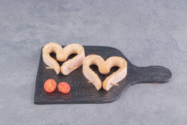 Domates ve kalp şeklinde sosis tahtada, mermer zeminde. Yüksek kalite fotoğraf