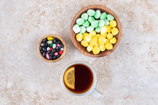 大理石を背景にしたキャンディとお茶のおいしいサービス 高品質の写真 — ストック写真