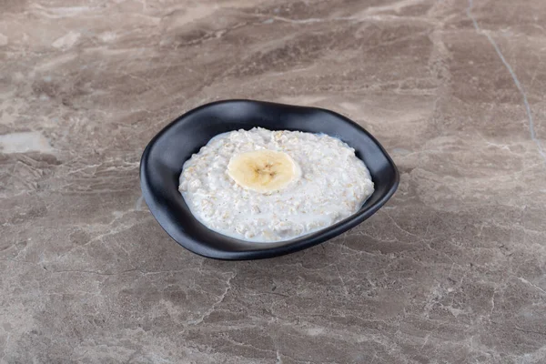 成熟的香蕉片在一碗粥上 在大理石背景上 高质量的照片 — 图库照片