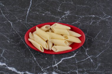 Kırmızı kasede siyah arka planda makarna. Yüksek kalite fotoğraf