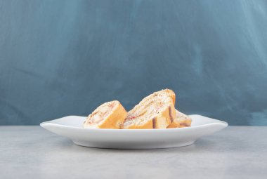 Mermer arka planda, tabakta dilimlenmiş bir kek. Yüksek kalite fotoğraf