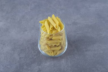 Taş zemin üzerinde cam içinde pişmemiş makarna. Yüksek kalite fotoğraf