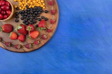 Mavi arka planda böğürtlen dolu tahta bir tahta. Yüksek kalite fotoğraf