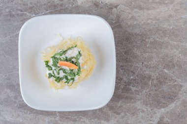 Tabağında havuç olan, mermer zemin üzerinde taze pişmiş spagetti. Merhaba kaliteli fotoğraf.