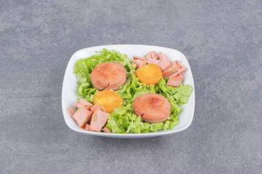 Marul yaprakları ve sosis tabakta, mermer zemin üzerinde. Yüksek kalite fotoğraf