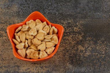 Turuncu kasede kalp şeklinde tuzlu krakerler. Yüksek kalite fotoğraf