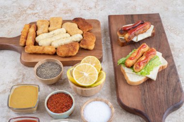 Peynirli, tavuk nuggetlı ve çeşit çeşit soslu ızgara sosisli sandviç. Yüksek kalite fotoğraf