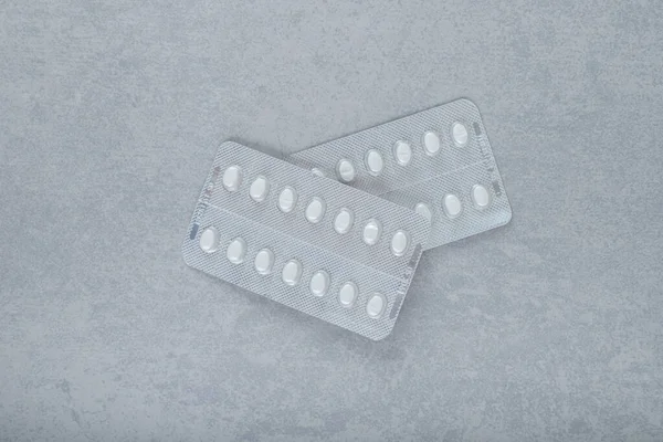 Two blisters with pills on a gray background. High quality photo