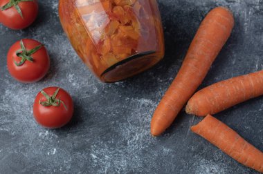 Havuçlu ve cam kavanozlu taze kırmızı domatesler. Yüksek kalite fotoğraf