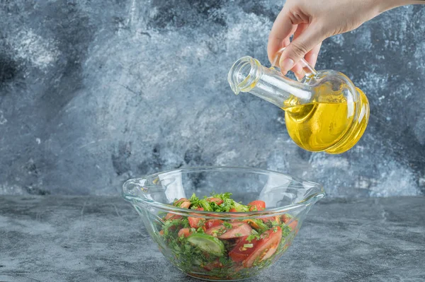 El, sebze salatasına yağ döküyor. Yüksek kalite fotoğraf
