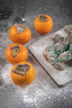 Siyah arka planda taze fuyu ve kurutulmuş hurma meyveleri. Yüksek kalite fotoğraf