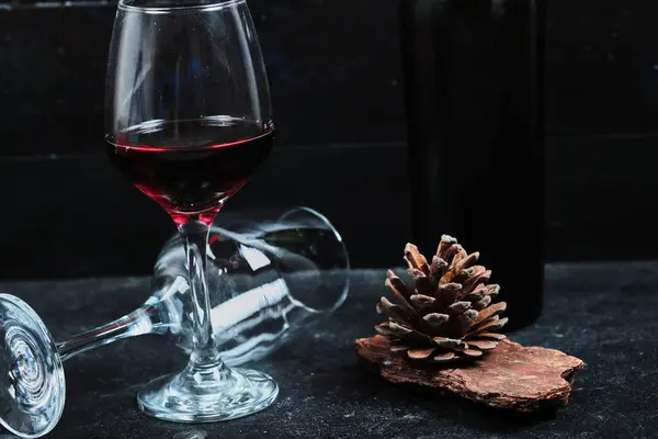 Bril Rode Wijn Met Fles Dennenappel Stenen Tafel Hoge Kwaliteit — Stockfoto