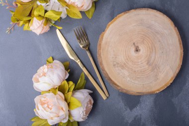 Yapay çiçekler, ahşap ve altın çatal bıçak takımı mavi arka planda. Yüksek kalite fotoğraf