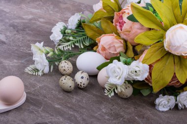 Etrafında çiçek buketi olan mermerin üzerinde yumurtalar. Yüksek kalite fotoğraf