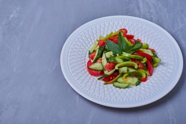 Mavi arka planda beyaz tabakta sebze salatası. Yüksek kalite fotoğraf