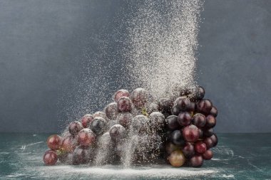 Mermer masa üzerinde toz ile süslenmiş siyah üzümler. Yüksek kalite fotoğraf