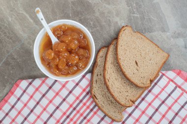 Çavdar ekmeği dilimleri ve mermer yüzeyde masa örtüsü ile çilek reçeli. Yüksek kalite fotoğraf