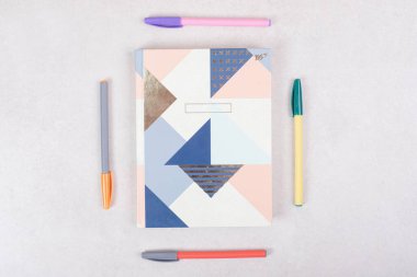 Beyaz arka planda güzel defterleri olan beş renkli kalem. Yüksek kalite fotoğraf