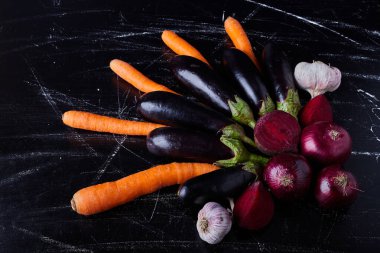 Siyah arka planda mor patlıcan ve diğer sebzeler. Yüksek kalite fotoğraf