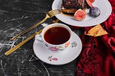 Beyaz tabakta çay ve incirli bir dilim çikolatalı pasta. Yüksek kalite fotoğraf