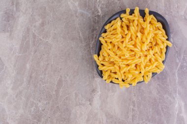 Siyah seramik kasede pişirilmemiş makarna. Yüksek kalite fotoğraf