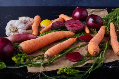 Kağıdın üzerindeki siyah arka planda sebze kompozisyonu. Yüksek kalite fotoğraf