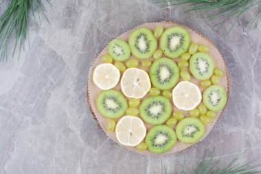 Tahta tahtada bir dilim kivi, üzüm ve limon. Yüksek kalite fotoğraf