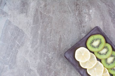 Siyah tabakta bir dilim kivi ve limon. Yüksek kalite fotoğraf