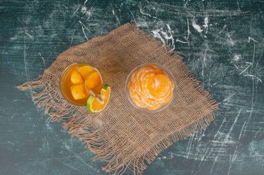 Bir bardak meyve suyu ve mermer zemin üzerinde mandalina dilimleri. Yüksek kalite fotoğraf