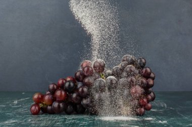 Mermer masa üzerinde toz ile süslenmiş siyah üzümler. Yüksek kalite fotoğraf