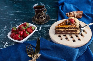 Bir dilim çikolatalı pasta, bir bardak çay ve meyveli. Yüksek kalite fotoğraf