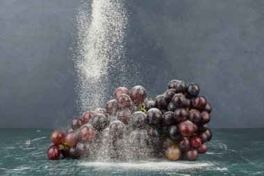 Mermer masa üzerinde toz ile süslenmiş siyah üzümler. Yüksek kalite fotoğraf
