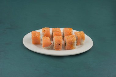 Philadelphia suşi böreği, beyaz tabakta susam tohumlarıyla süslenmiş. Yüksek kalite fotoğraf