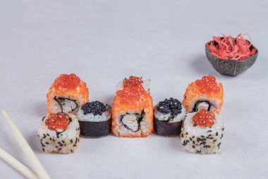 Klasik üç çeşit suşi çubuklu beyaz arka planda yuvarlanıyor. Yüksek kalite fotoğraf