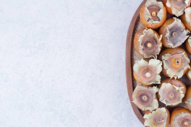 Sarı hurma erikleri gri arka planda ahşap bir tabakta. Yüksek kalite fotoğraf