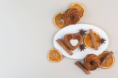 Beyaz tabakta portakal dilimli, karanfil ve tarçınlı çeşitli kekler. Yüksek kalite fotoğraf