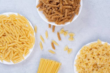 Beyaz arka planda çeşitli pişmemiş makarna. Yüksek kalite fotoğraf