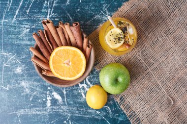 Mavi arka planda bir bardak içkili limon ve tarçın. Yüksek kalite fotoğraf