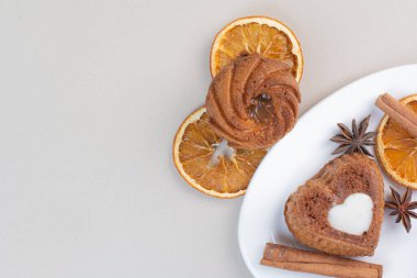 Beyaz tabakta portakal dilimli pasta, karanfil ve tarçın. Yüksek kalite fotoğraf