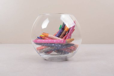 Beyaz arkaplanda camlı renkli boya kalemleri