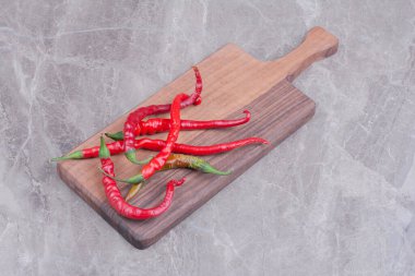 Ahşap bir tabakta izole edilmiş kırmızı biberler. Yüksek kalite fotoğraf