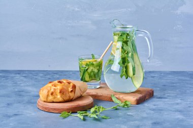 Mavi arka planda ahşap bir tahtada mojito kokteyli ile çörek. Yüksek kalite fotoğraf
