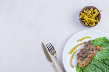 Beyaz tabakta ızgara kuzu pirzola ve biber turşusu. Yüksek kalite fotoğraf