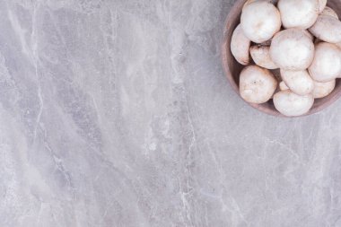 Mermerin üzerinde pişmemiş mantar dolu ahşap bir fincan. Yüksek kalite fotoğraf