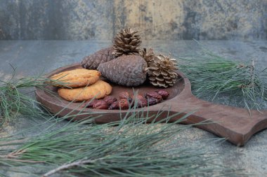 Kurabiye, kurumuş gül kalçası ve tahta tahtada kozalak. Yüksek kalite fotoğraf