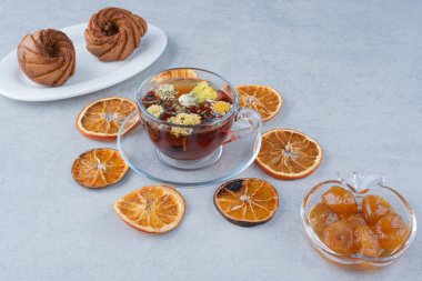 Kurutulmuş portakallı tatlı pasta ve mermer zemin üzerinde bitki çayı. Yüksek kalite fotoğraf